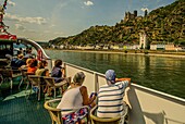 Passengers of a panorama ship look at the old town of St. Goarshausen, Upper Middle Rhine Valley, Rhineland-Palatinate, Germany