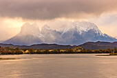View over the Torres del Paine mountain range with dramatic rain clouds in the back light, southern Patagonia, Chile, South America