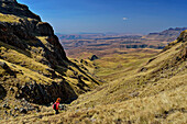 Woman hiking descends from Langalibalele Pass, Langalibalele Pass, Giant's Castle, Drakensberg Mountains, Kwa Zulu Natal, Maloti-Drakensberg UNESCO World Heritage Site, South Africa