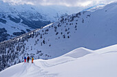 Three people on a ski tour descending from Kleiner Gamsstein, Kleiner Gamsstein, Hochfügen, Tux Alps, Tyrol, Austria