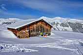 Mann und Frau auf Skitour machen an Almhütte Pause, Schönbichl, Gerlos, Zillertaler Alpen, Tirol, Österreich