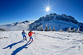 Mann und Frau beim Winterwandern am Sulten, Kampenwand im Hintergrund, Chiemgauer Alpen, Oberbayern, Bayern, Deutschland
