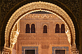 Ein verzierter Torbogen der Nasridenpaläste im Gegenlicht, die bedeutende Burganlage Alhambra, Granada, Andalusien, Spanien
