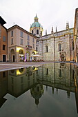 Terrace of an enoteca on the Piazza Guido Grimoldi reflected in a fountain, behind it the Cathedral di Santa Maria Assunta, Como, Lake Como, Lombardy, Italy
