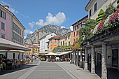In Piazza XX. Settembre with the terraces of restaurants and cafes in the old town of Lecco, Lake Como, Lombardy, Italy