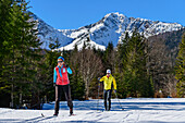 Man and woman cross-country skiing through the Kloo-Aschertal, Bayrischzell, Mangfall Mountains, Bavarian Alps, Upper Bavaria, Bavaria, Germany