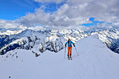 Woman on ski tour climbs over snow ridge to Grinbergspitze, Grinbergspitze, Tuxer Kamm, Zillertal Alps, Tyrol, Austria