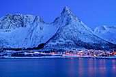 Beleuchtete Ortschaft Mefjordvaer am Mefjord mit Bergen im Hintergrund, Mefjord, Senja, Troms og Finnmark, Norwegen