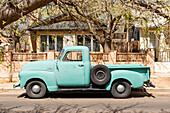 Sun bleached green oldtimer pick up truck parked in the streets of Albuquerque, New Mexico.