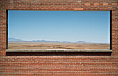 Arizona-Landschaft hinter einer roten Backsteinmauer, USA