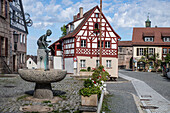 Cadolzburg market, half-timbered house and Brestlasbrunnen (strawberry fountain) by Gudrun Kunstmann (2017-1994) at the entrance to the castle, Franconia, Bavaria, Germany