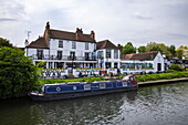 Canal barge Penny Rose moored in front of the Olde Swan Hotel on the River Thames, Chertsey, Surrey, England, United Kingdom