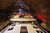 Besatzung mit Schwimmwesten an Bord von einem Le Boat Horizon 5 Hausboot bei Fahrt durch Tunnel auf dem Canal de la Marne au Rhin, Saint-Louis,  Moselle, Grand Est, Frankreich