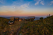 Grootbos-Allradfahrzeuge auf einem Bergrücken mit Gästen bei Sonnenuntergang, Grootbos Private Nature Reserve, Westkap, Südafrika