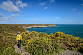 Frau wandert auf Wanderweg entlang der Steilküste mit Blick übers Meer, beim Cap Fréhel, Côte d'Émeraude, Smaragdküste, Bretagne, Frankreich