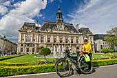 Frau beim Radfahren am Loire-Radweg steht vor Springbrunnen und Gartenanlage mit Rathaus von Tours, Tours, Loiretal, UNESCO Welterbe Loiretal, Frankreich