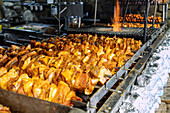 Shish kebab skewers, baked potatoes and grilled Polish sausages at a street grill in Zakopane in Poland