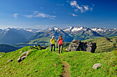 Man and woman hiking climb up to Salzachgeier, Zillertal Alps in the background, Salzachgeier, Kitzbühel Alps, Tyrol, Austria