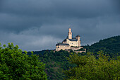 Die Marksburg bei Braubach, Sitz der Deutschen Burgenvereinigung, vor düsterem Himmel, UNESCO-Welterbe, Rheinland-Pfalz, Deutschland