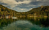 View over Lake Wolfgangsee with boats, boathouses and the hamlet of Brunnwinkl on the eastern shore of the lake, St. Gilgen, Salzburger Land, Austria