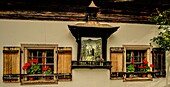 Alpine house on Lake Wolfgangsee with a portrait of the Virgin Mary, shutters and floral decorations, St. Gilgen, Salzburg State, Alps, Austria
