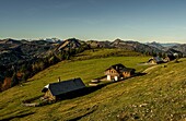 Blick vom Schafberg auf Landhäuser nahe der Schafbergalm, im Hintergrund Almwiesen und die Berge des Salzkammerguts, Österreich