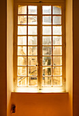 Sun shining through a glass pane window in Arles, France.