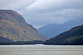 Chile; Southern Chile; Magallanes Region; Mountains of the southern Cordillera Patagonica; on the Navimag ferry through the Patagonian fjords; Angostura Inglesa; Sun and clouds alternate; View of the forested mountain slopes