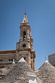 Blick auf die Chiesa dei Santi Medici Cosma e Damiano, im Vordergrund Trulli Dächer, Gemeinde Alberobello, Provinz Bari, Region Apulien, Italien, Europa