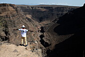  Man spreads his arms and looks at Belvedere Sul Canyon, near Arta, Djibouti, Middle East 