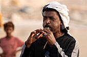  Local man plays flute to see off visitors at the pier, near Hadibu, Socotra Island, Yemen, Middle East 
