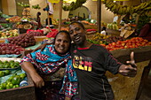 Freundliche Einheimische an einem Obst- und Gemüsestand in der Markthalle, Lamu, Insel Lamu, Kenia, Afrika