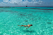 Frau badet im seichten Wasser vor dem Expeditionskreuzfahrtschiff SH Diana (Swan Hellenic), Insel Assomption Island, Outer Islands, Seychellen, Indischer Ozean