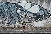  Young boy stares at a mural of a whale in the streets of Ponta Delgada, Sao Miguel, Azores. 