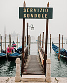 Gondeln vertäut am Canal Grande in Venedig mit der Basilika Santa Maria Della Salute im Hintergrund. Venedig, Italien