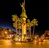 Victoria-Statue an einer Prachtstraße mit Palmen bei Nacht, Puerto Banús, Marbella, Costa del Sol, Andalusien, Spanien