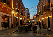 Restaurant tables in street at night with hanging lights, Campeche city, Campeche State, Mexico