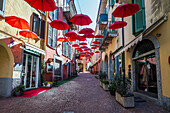  Red umbrellas in the old town of Luino, Varese province, Lake Maggiore, Lombardy, Italy, Europe 