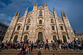 Menschen auf den Stufen vor dem Mailänder Dom bei Sonnenuntergang, Piazza del Duomo, Mailand, Lombardei, Italien, Europa