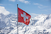  Swiss flag in front of an impressive Alpine backdrop, Alps, Wengen, Grindelwald, Canton of Bern, Bern, Switzerland, Europe 