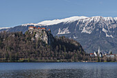 View of Bled Castle and the snow-capped mountains behind it in Bled, Slovenia, Europe. 