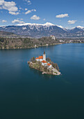  Aerial view of St. Mary&#39;s Church in Lake Bled and snowy mountains in Bled, Slovenia, Europe. 