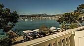 Blick vom Balkon von Hotel Illa d'Or über den Pine Walk und das Meer auf Port de Pollenca, im Hintergrund das Tramuntana-Gebirge, Mallorca, Spanien
