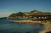 Blick auf die Platja de Sant Joan, Segelboot und das Tramuntana-Gebirge im Hintergrund, Alcudia, Mallorca, Spanien