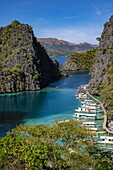  View of Bangka outrigger canoe tour boats moored in the lagoon, seen from the observation deck en route to Kayangan Lake, Coron, Palawan, Philippines 