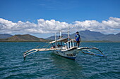  Bangka outrigger canoe tour boat with coast in the distance, Honda Bay, near Puerto Princesa, Palawan, Philippines 