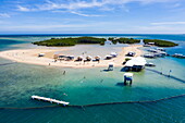  Aerial view of people relaxing on the beach and Bangka outrigger canoe tour boats on Luli Island, Honda Bay, near Puerto Princesa, Palawan, Philippines 