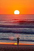 Europa, Portugal, Algarve, Sonnenuntergang, Atlantik, Surfer schaut auf das Meer