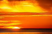 Sonnenuntergang am Meer mit Sonne und Wolken