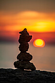 Steinskulptur am Meer bei Sonnenuntergang